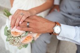 übereinanderliegende Hände des Brautpaares mit Eheringen