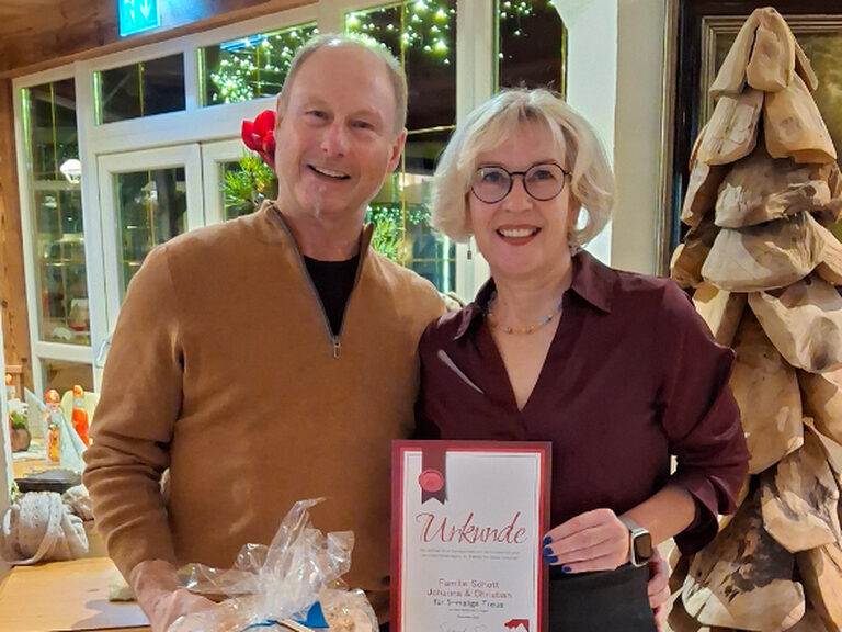 Paar posiert mit Urkunde anlässlich Gästeehrung