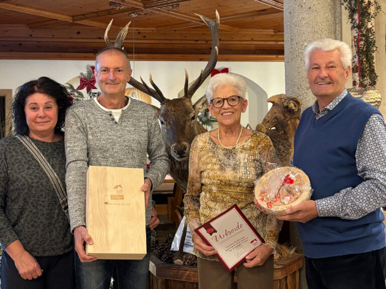 Familie posiert anlässlich Gästeehrung mit Urkunde und Geschenk