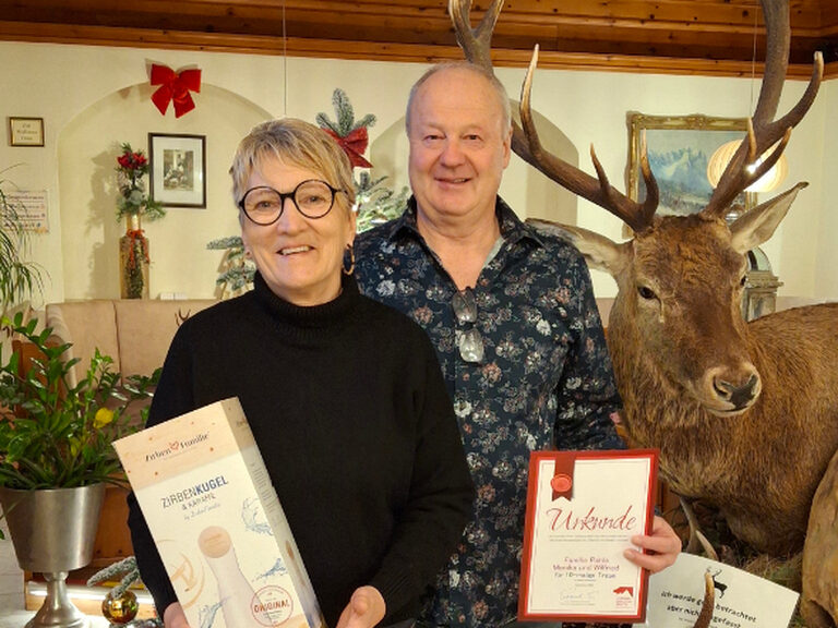 Paar posiert mit Gästeehrungsurkunde