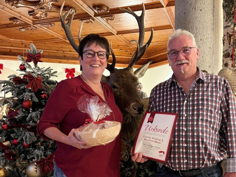 Paar posiert mit Urkunde anlässlich Gästeehrung