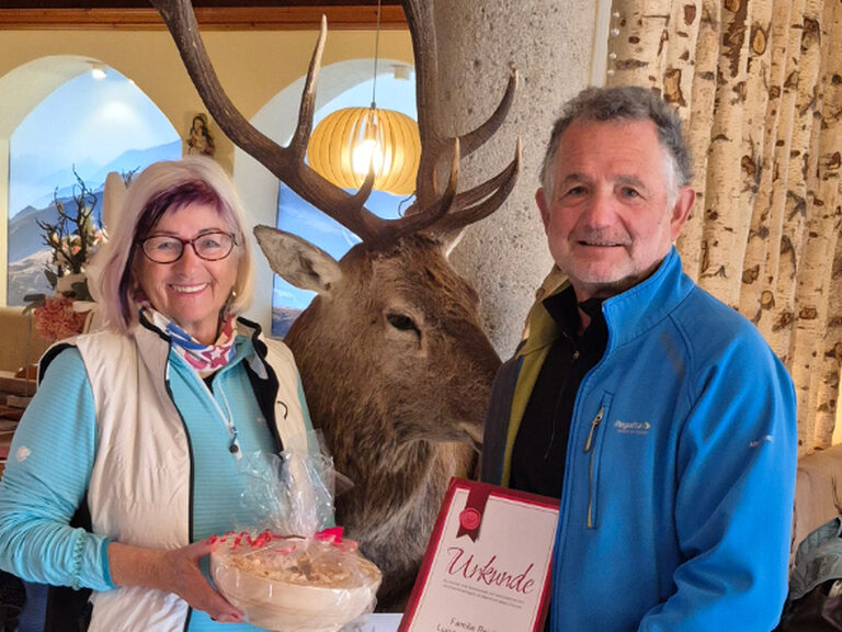 Paar posiert lächelnd mit der Ehrenurkunde in der Hand