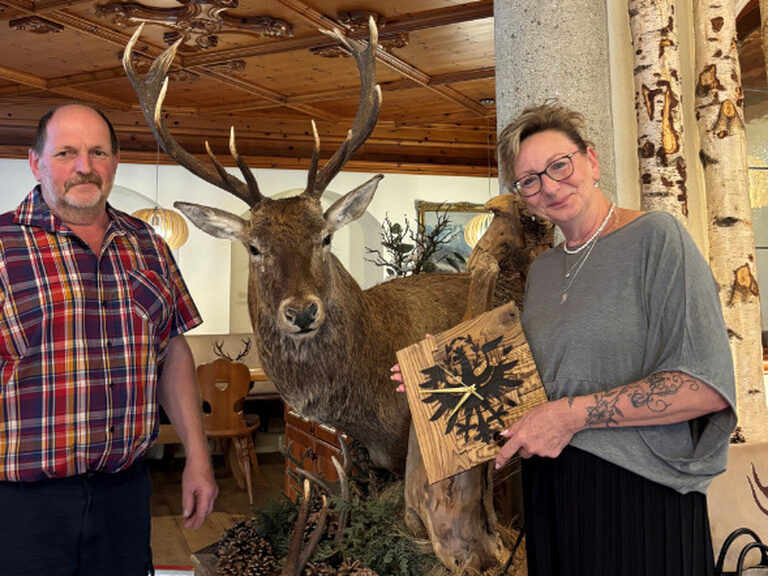 Paar posiert mit Geschenk vom Hotel Kohlerhof anlässlich des 20. Aufenthalts