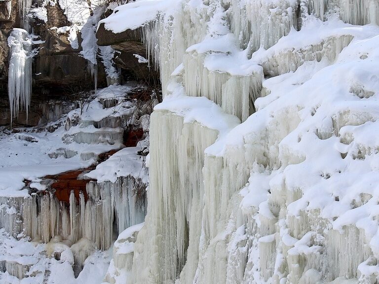 Eine große Fläche an Eiszapfen, die vom Felsen hängen
