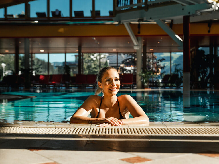 Frau entspannt im Wasser des Erlebnishallenbades