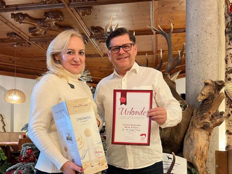 Paar posiert mit Urkunde anlässlich Gästeehrung