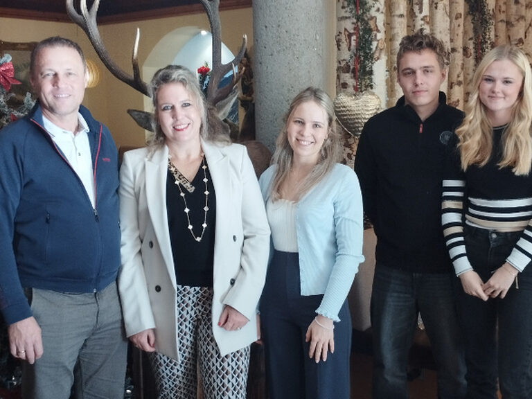 Familie posiert anlässlich Geburtstag, im Hintergrund ist weihnachtliche Deko zu sehen