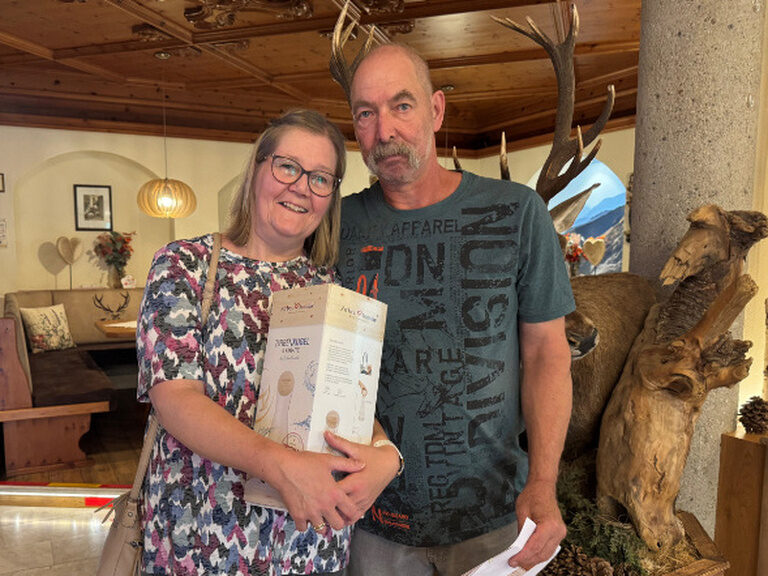 Paar posiert mit Geschenk vom Hotel Kohlerhof anlässlich Ehrung