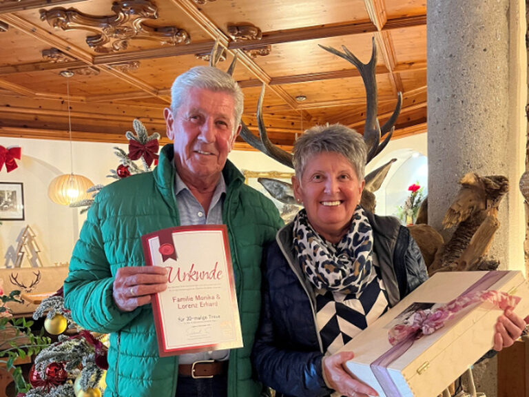 Paar posiert mit Urkunde und Geschenk anlässlich Gästeehrung