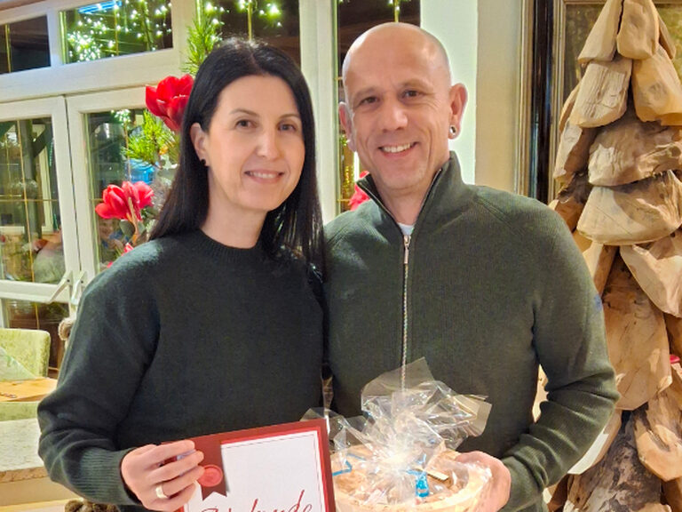 Paar posiert mit Urkunde anlässlich Gästeehrung