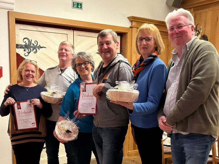 Familie posiert mit Urkunde anlässlich Gästeehrung