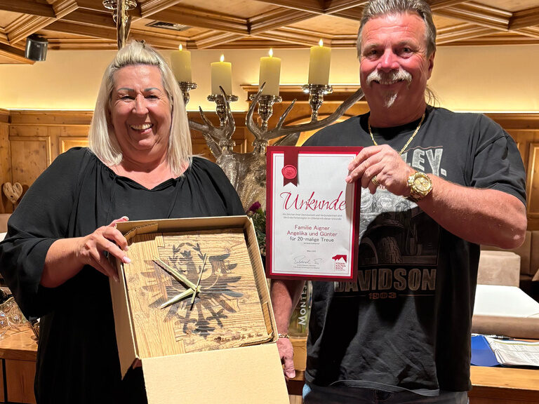 Paar posiert mit Urkunde anlässlich Gästeehrung