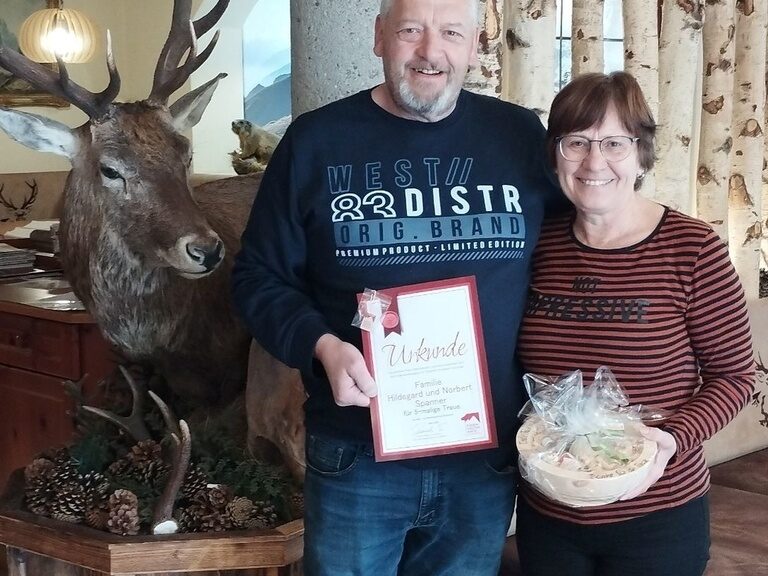 Paar posiert mit Urkunde anlässlich Gästeehrung