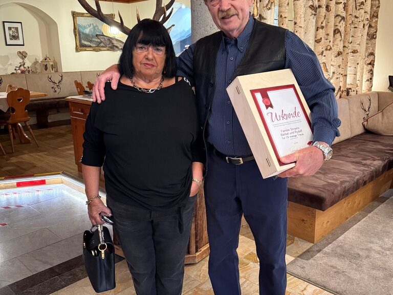 Paar posiert mit Urkunde anlässlich Gästeehrung