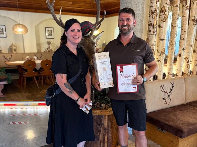 Paar posiert mit Urkunde anlässlich Gästeehrung