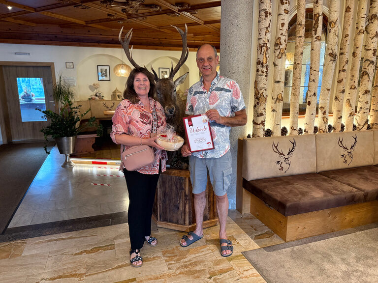 Paar posiert mit Urkunde anlässlich Gästeehrung