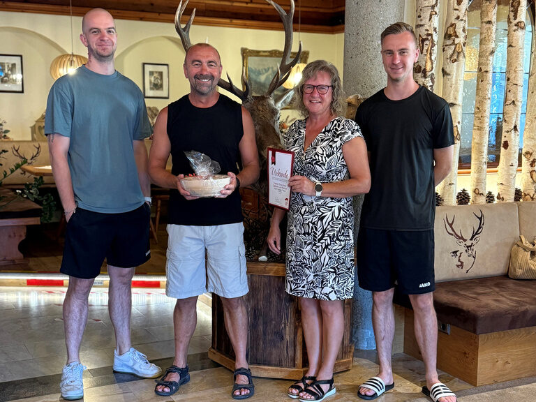 Familie posiert im Hotel mit Urkunde anlässlich Gästeehrung