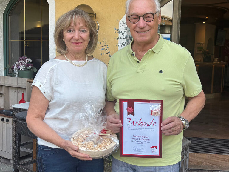 Paar posiert vor dem Hotel anlässlich Gästeehrung