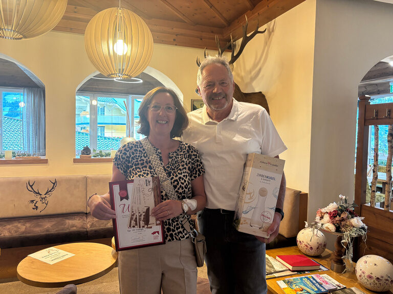 Paar posiert mit Urkunde anlässlich Gästeehrung