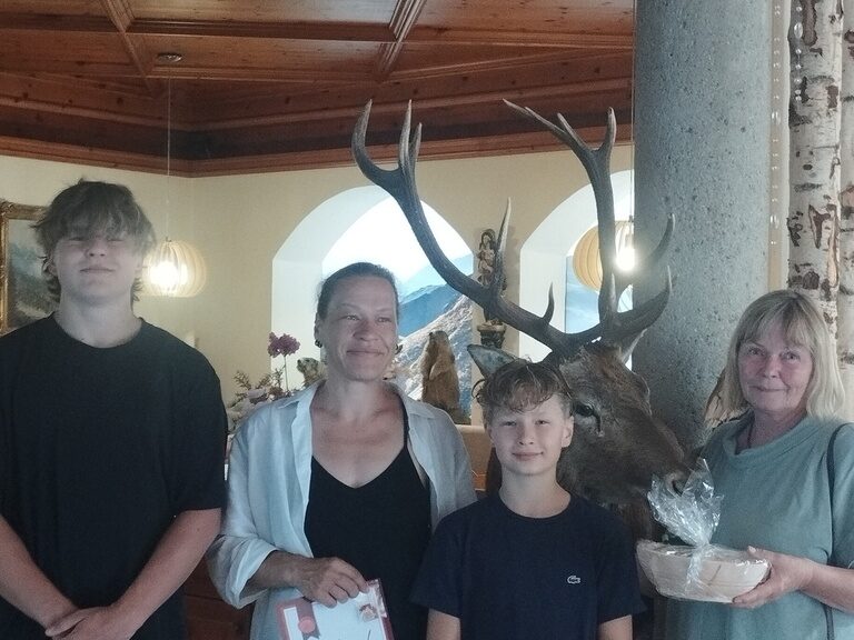 Familie posiert im Hotel mit Urkunde anlässlich Gästeehrung