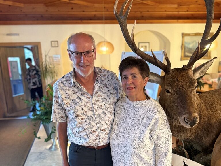 Paar posiert mit einer Urkunde anlässlich Gästeehrung