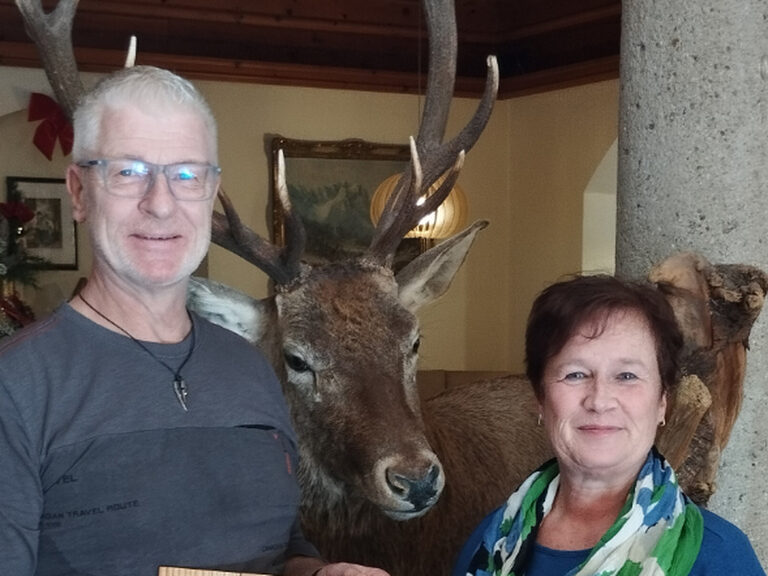 Gäste posieren mit Urkunde und Geschenk anlässlich Stammkunden-Ehrung