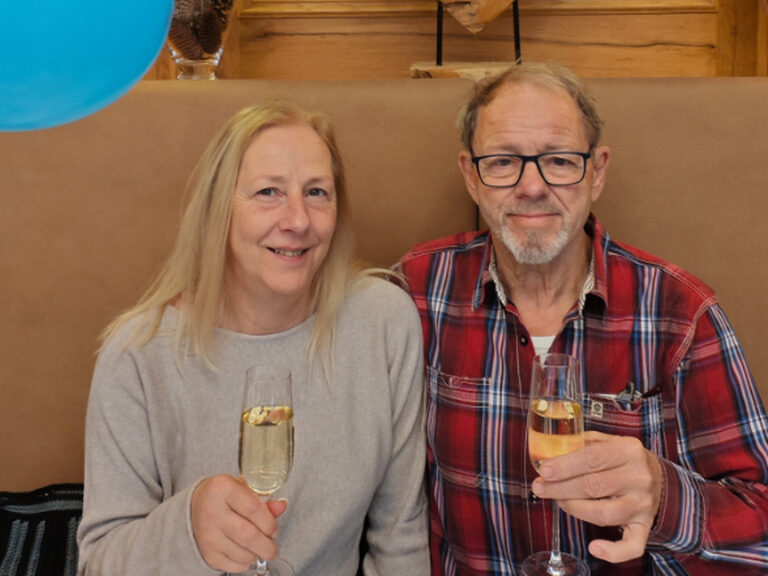 Paar posiert mit Sektglast anlässlich Geburtstag