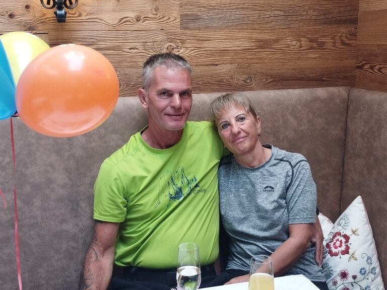 Paar sitzt am Frühstückstisch und posiert anlässlich Geburtstag