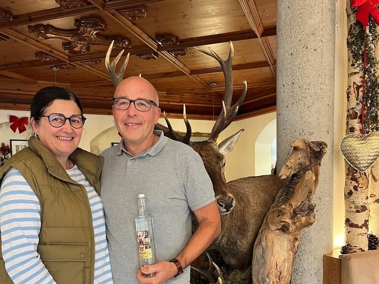 Gäste posieren anlässlich Geburtstag mit einer Flasche Schnaps in der Hand