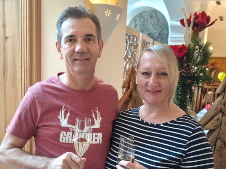 Paar posiert mit einem Glas Sekt anlässlich Geburtstag