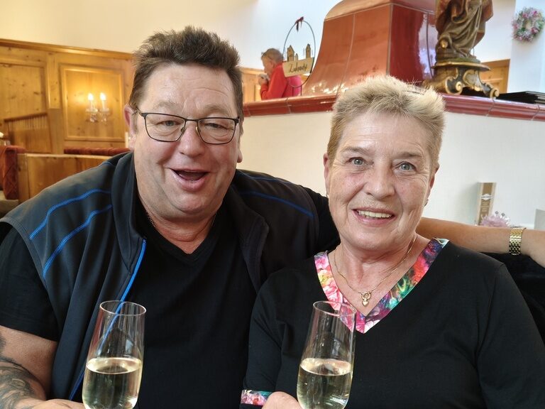 Paar posiert mit Sektgläserin anlässchlich Geburtstag