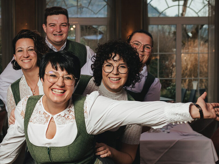 Die fünf Geschwister der Familie heim lächelt fröhlich in der Tracht gekleidet in die Kamera