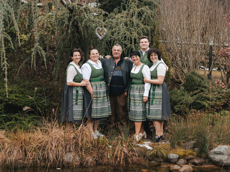 Die Gastgeberfamilie des Kohlerhof im Zillertal posiert im Grünen für ein gemeinsames Foto.