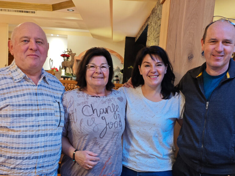 zwei Männer und zwei Frauen lächeln und posieren anlässlich Geburtstag