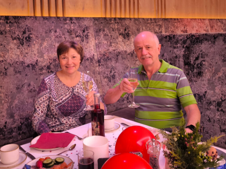 Paar sitzt am dekorierten Geburtstagstisch