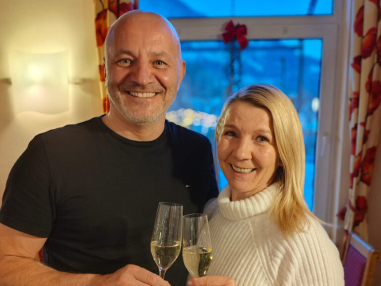 Paar posiert mit jeweils einem Glas Sekt in der Hand anlässlich Geburtstag
