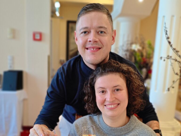 Aufgrund des Geburtstages der Frau posiert ein Paar mit Sektglas