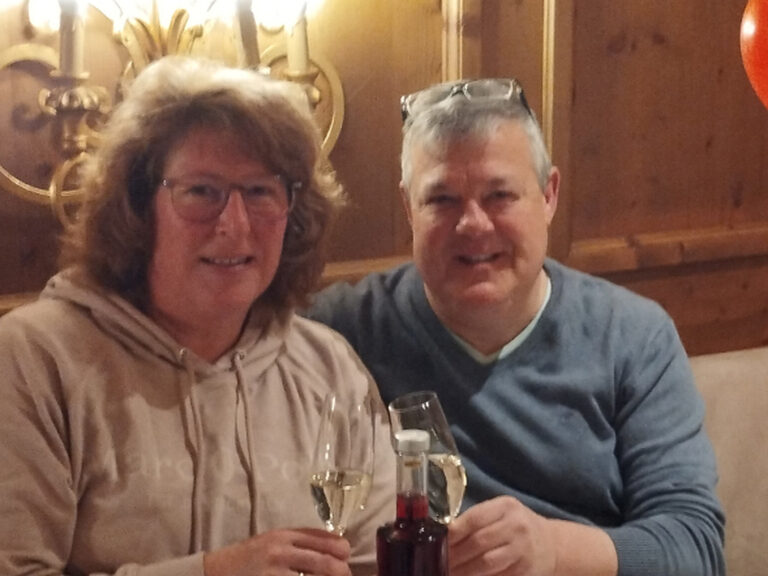 Paar prostet mit einem Sektglast anlässlich Geburtstag zu