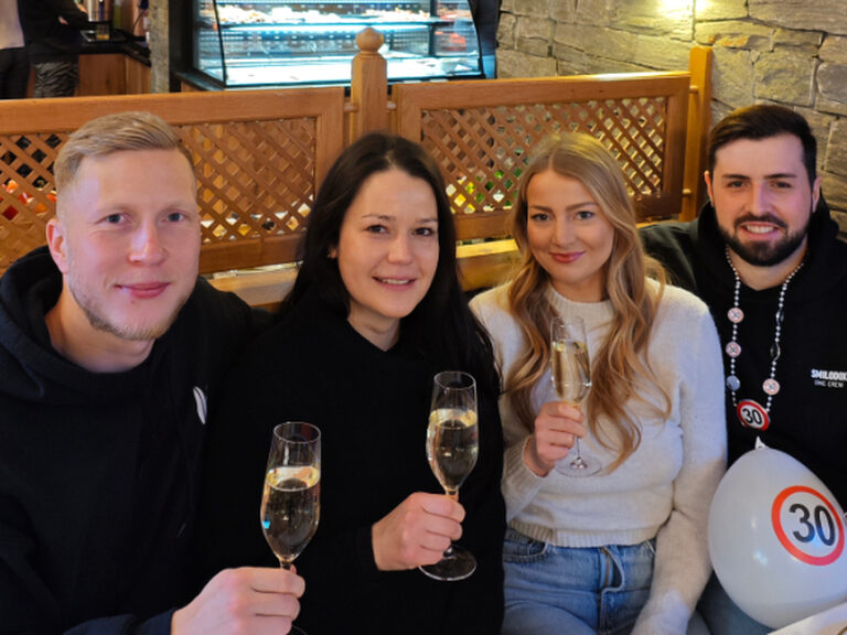 vier Personen sitzen feinernd am Tisch anlässlich eines 30. Geburtstags