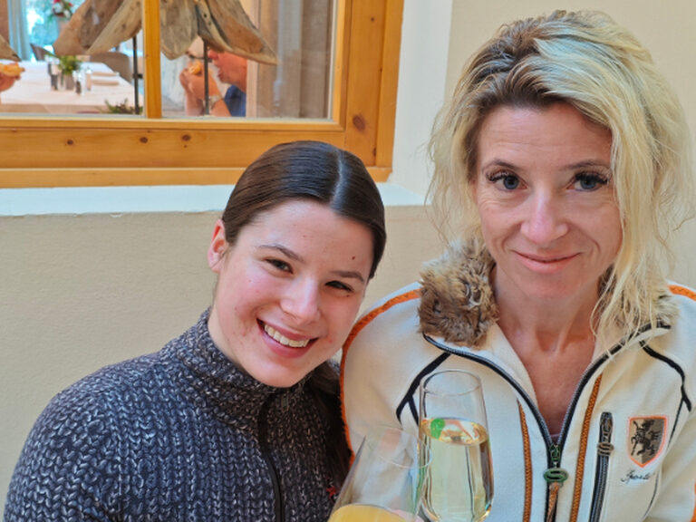 Frau und Mädchen posieren mit Orangensaft und Sekt anlässlich Geburtstag