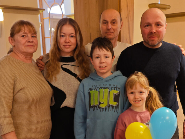 Familie posiert mit bunten Luftballonen anlässlich Geburtstag