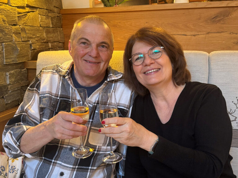 Paar stößt anlässlich eines Geburtstags mit einem Glas Sekt an