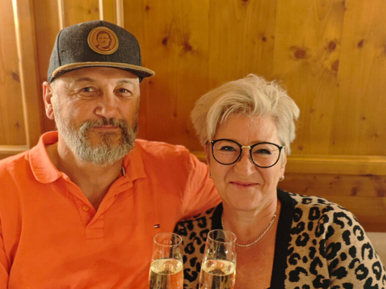 Paar posiert mit einem Glas Sekt anlässlich Geburtstag