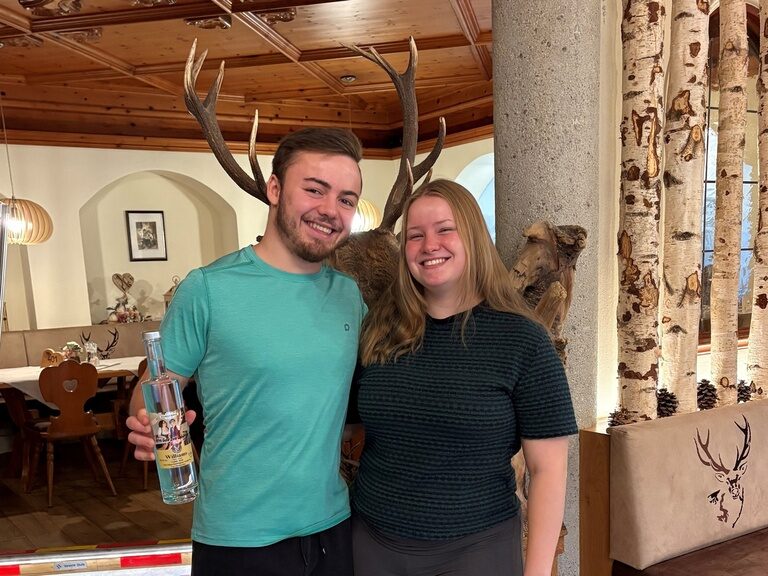 Paar posiert mit Schnapsflasche anlässlich Geburtstag