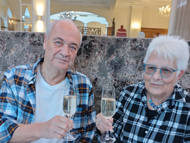 Paar stoßt anlässlich Geburtstag mit einem Glas Sekt an