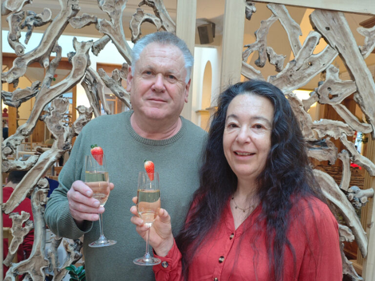 Paar posiert mit einem Glas Sekt anlässlich eines Geburstags