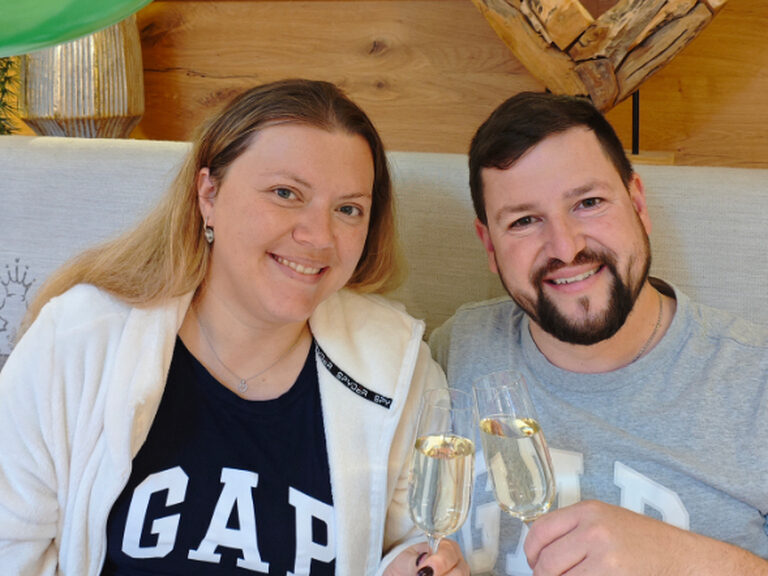 Paar stößt anlässlich Geburtstag mit einem Glas Sekt an