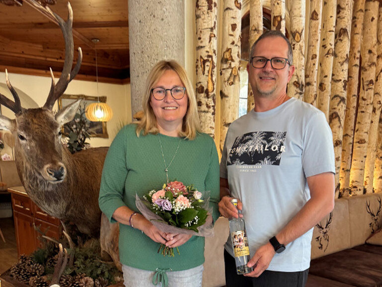Paar posiert mit Geschenk vom Hotel anlässlich eines Geburtstags