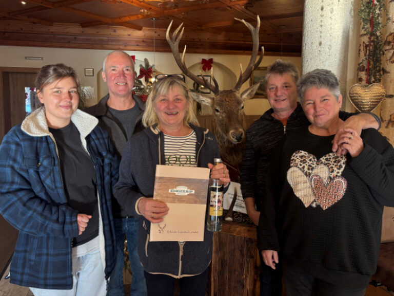 Fünf Personen posieren mit Urkunde und Geschenk anlässlich Geburtstag