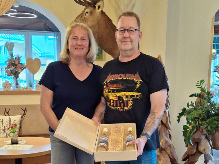 Paar posiert mit Geschenk vom Hotel